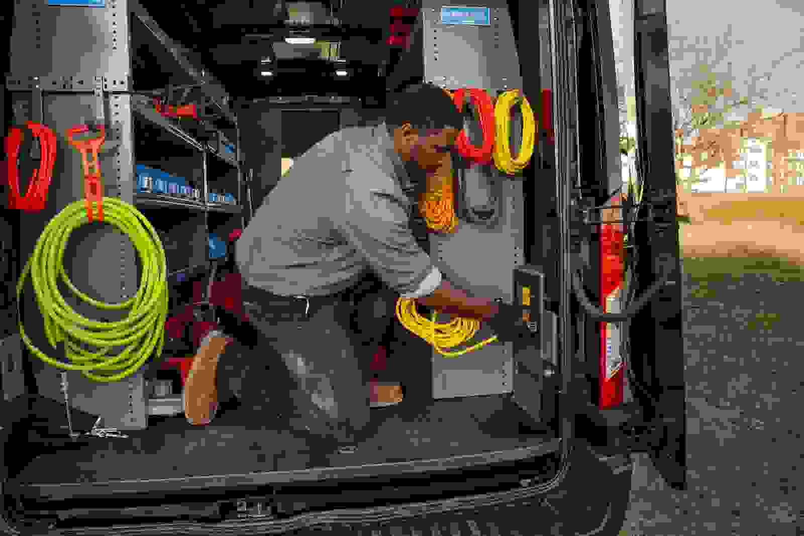 Person in a work van with colorful extension cords